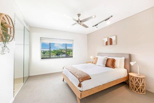 a white bedroom with a bed and a window at 'Lady of the Lagoon' Spacious Waterfront Luxury in Darwin