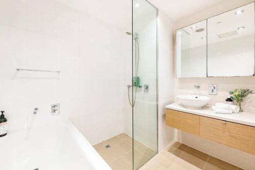 a white bathroom with a sink and a shower at 'Lady of the Lagoon' Spacious Waterfront Luxury in Darwin