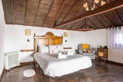 een slaapkamer met een bed en een stoel erin bij Villa Rural La Zarza by Sunkeyrents in Fasnia