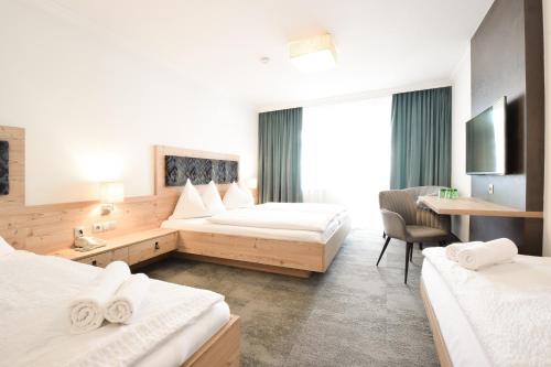 um quarto de hotel com duas camas e uma secretária em Pension Ebnerwirt em Eben im Pongau