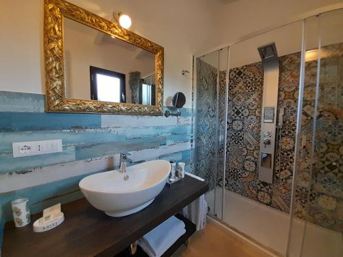 ein Bad mit einem Waschbecken und einem Spiegel in der Unterkunft Maria Caderina Green Village in Posada