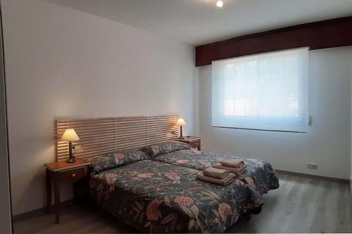 1 dormitorio con 1 cama, 2 lámparas y ventana en Vistas a la ría de Muros Noia en Portosín, en Portosín