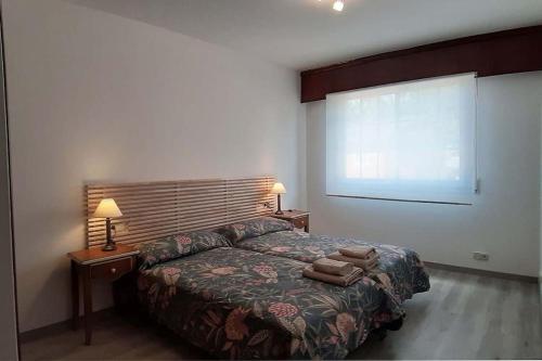 a bedroom with a bed and two lamps and a window at Vistas a la ría de Muros Noia en Portosín in Portosin