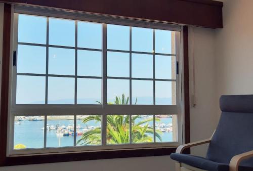 a large window with a view of a beach at Vistas a la ría de Muros Noia en Portosín in Portosin