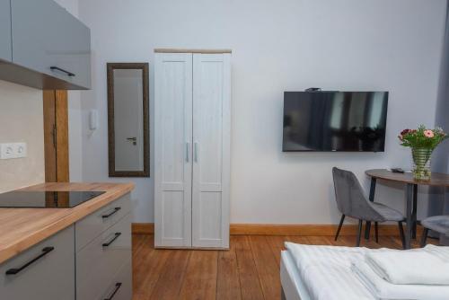a kitchen with a white cabinet and a table at PROVENIR HOME KWIATOWA 5 in Poznań