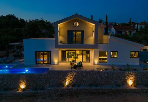 a house with a clock on top of it at night at Vila Tramonto in Pinezici
