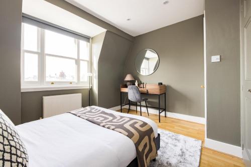 - une chambre avec un lit et un bureau avec un miroir dans l'établissement The London Crib - Relaxing 1BDR Flat with Terrace, à Londres