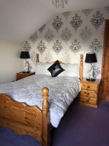 um quarto com uma cama de madeira com 2 candeeiros e uma parede em Eden House em Carlingford