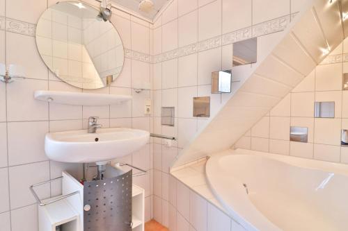 a bathroom with a sink and a bath tub at Kiek rin bi Kati - Ferienwohnung 4 in Langeoog