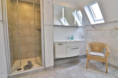 a bathroom with a shower and a sink and a chair at Kiek rin bi Kati - Ferienwohnung 2 in Langeoog