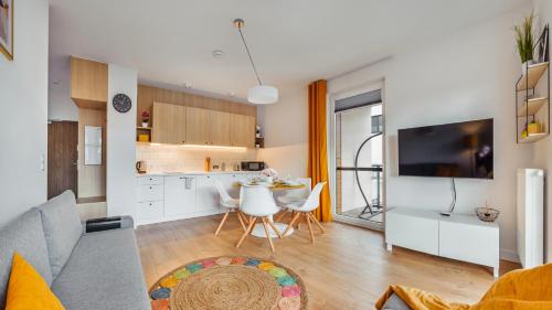 a living room with a couch and a table and a kitchen at Nexo, Sun & Snow in Puck