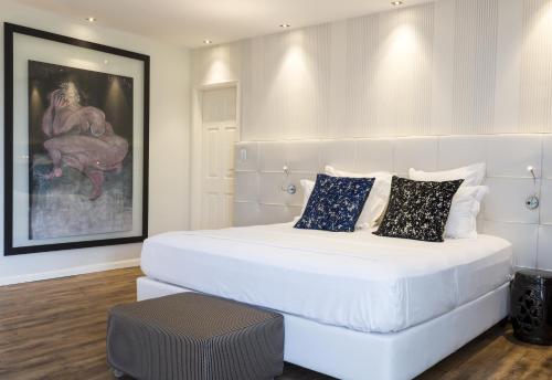 a large white bed in a room with a painting at Prestige Property - Da Costa in Rio de Janeiro