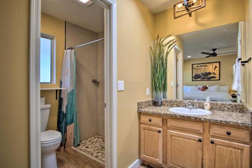 a bathroom with a sink and a toilet and a mirror at Eastside Home with Pool Near Hiking! in Tucson