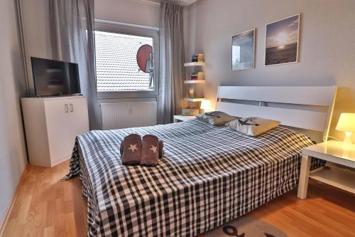 - une chambre avec un lit doté de tongs dans l'établissement Salini, à Langeoog