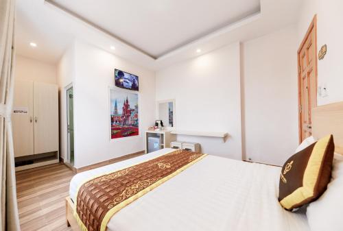 a bedroom with a large bed in a room at Golden Bee Hotel in Da Lat