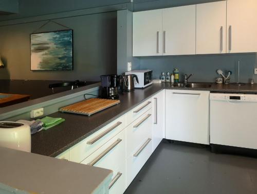 uma cozinha com armários brancos e uma bancada em Sund sommerhotell, Inderøy em Straumen