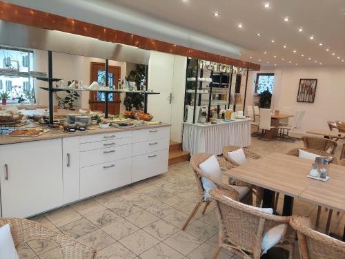 翁特拉梅尔高Gästehaus u Ferienwohnungen Veronika incl Frühstücksbuffet und KönigsCard mit 200 kostenlosen Attraktionen的配有桌椅的厨房和餐厅