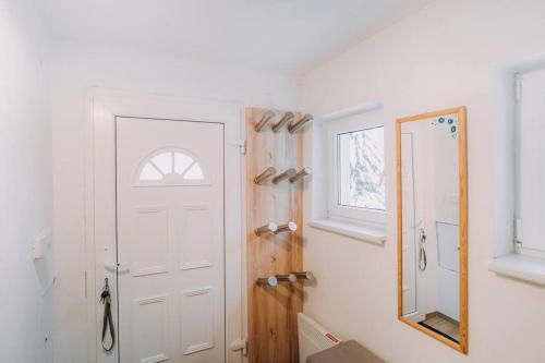 a bathroom with a white door and a mirror at Chata Franka in Donovaly