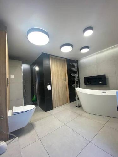 duża łazienka z wanną i toaletą w obiekcie Apartament Północny z Tarasem w Żorach