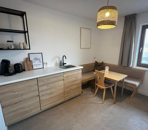 uma cozinha com uma mesa, um lavatório e uma mesa em Hotel Der Drahtesel em Bramberg am Wildkogel
