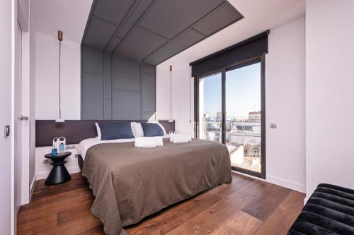 a bedroom with a large bed and a large window at Sweet Inn - Palau in Barcelona