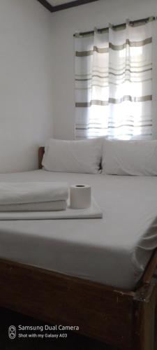 a white bed with a plate on top of it at Dhadas place in San Vicente