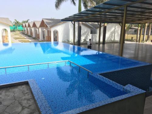 una gran piscina con azulejos azules. en VITS Daman Devka Beach, en Daman