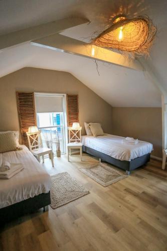 a bedroom with two beds and a window at De Kroft Beach Residences Noordwijk aan Zee in Noordwijk