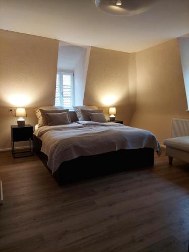 a bedroom with a large bed and two lamps at Unterm Walmdach No. 3 in Dinkelsbühl