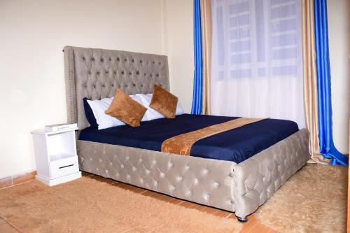 1 dormitorio con 1 cama con cabecero de metal en The Hideout Thika Town, en Thika
