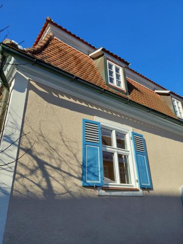 a house with blue shutters and a window at Unterm Walmdach No. 3 in Dinkelsbühl