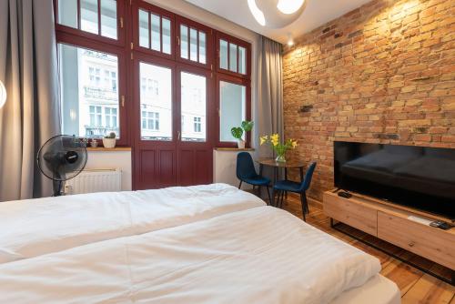 a bedroom with a large bed and a brick wall at PROVENIR HOME KWIATOWA 5 in Poznań