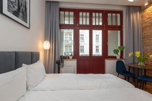 1 dormitorio con cama blanca y puerta roja en PROVENIR HOME KWIATOWA 5 en Poznan