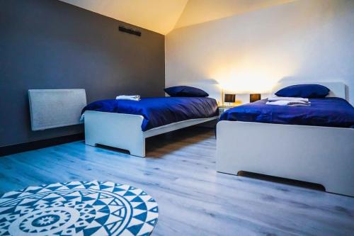 - une chambre avec 2 lits avec des draps bleus et une table dans l'établissement Le Loft • Spacieux • Fibre • Cour extérieure, à Déols