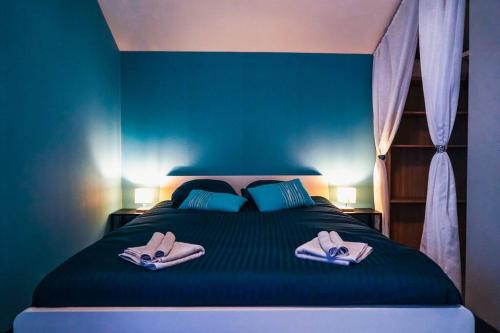 - une chambre bleue avec un lit et des chaussons dans l'établissement Le Loft • Spacieux • Fibre • Cour extérieure, à Déols