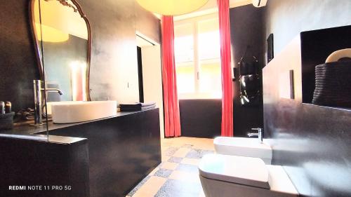 baño con lavabo, 2 aseos y espejo en Matilde Rooms en La Spezia