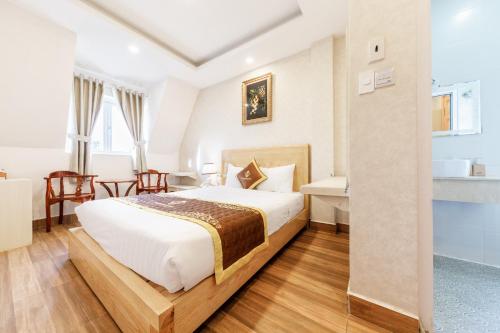 a hotel room with a bed and a desk at Golden Bee Hotel in Da Lat