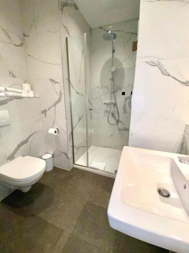 a bathroom with a shower and a toilet and a sink at Hotel Marc Aurel - Vienna City Center in Vienna