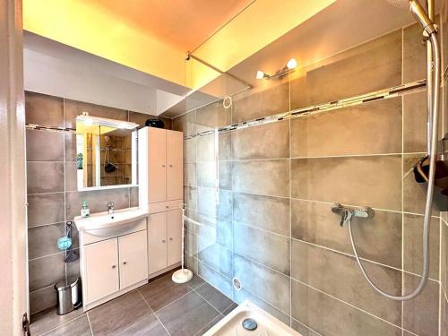 uma casa de banho com um chuveiro e um lavatório. em Viva Riviera Large 1 Bedroom with Sunny Terrace em Cannes