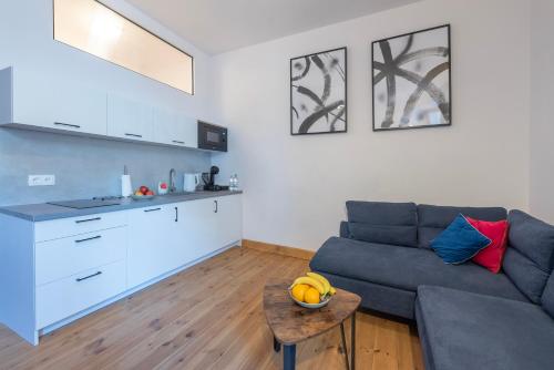 a living room with a couch and a table and a kitchen at PROVENIR HOME KWIATOWA 5 in Poznań