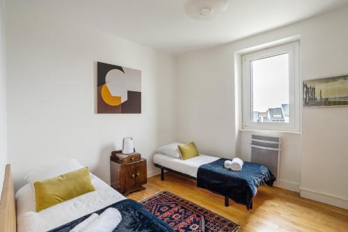 un salon avec un lit et une fenêtre dans l'établissement Le Beau Site - Proche plage parking privé, à Saint-Malo