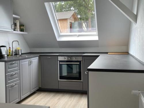 a kitchen with a stove and a window in it at Ferienwohnung Eulennest in Drolshagen