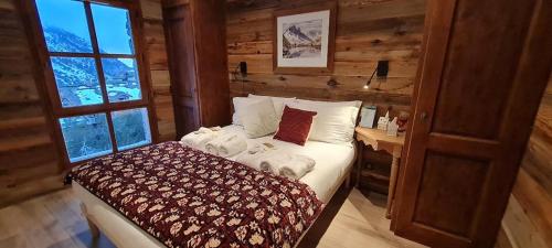 une chambre avec un lit dans une pièce avec une fenêtre dans l'établissement Refuge du Montagnard ARCS 1950, à Arc 1950