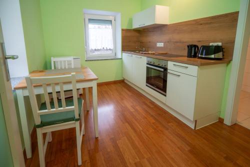 a small kitchen with a wooden table and a wooden floor at Monteur-/ Arbeiter-Apartment_ Wohnung 4 in Memmingen