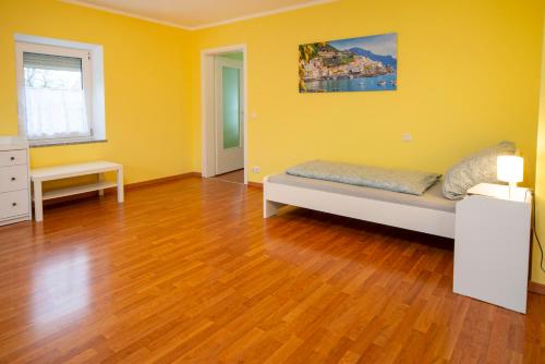 sala de estar con cama y suelo de madera en Monteur-/ Arbeiter-Apartment_ Wohnung 4, en Memmingen