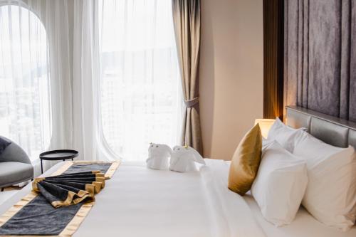a hotel room with a bed with pillows and a window at Grand Tourane Nha Trang Hotel in Nha Trang