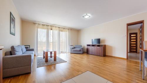 a living room with a couch and a table at Apartamenty Sun & Snow Rozewie in Jastrzębia Góra