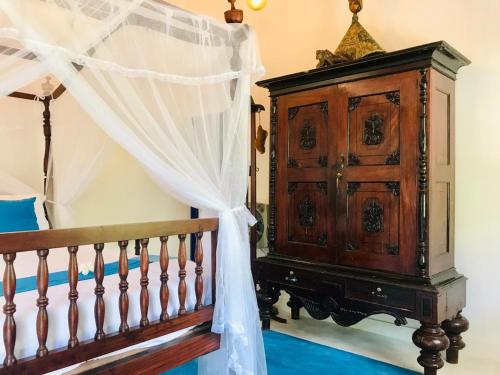 a bedroom with a wooden cabinet next to a bed at Sriyan Villa in Beruwala