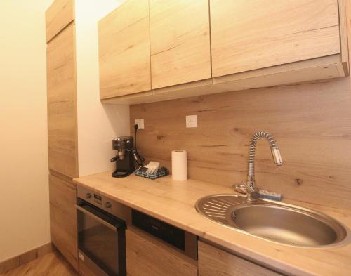 a kitchen counter with a sink and wooden cabinets at Super Flat, Garden. Bnbrickeys in Monte Carlo