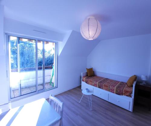 una camera da letto con un letto e una grande finestra di LE NID DE BATZ SUR MER-Studio-Les Gîtes de la Côte d'Amour a Batz-sur-Mer